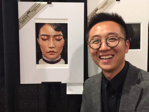 Travis Zhang beside his award-winning print at WPPI