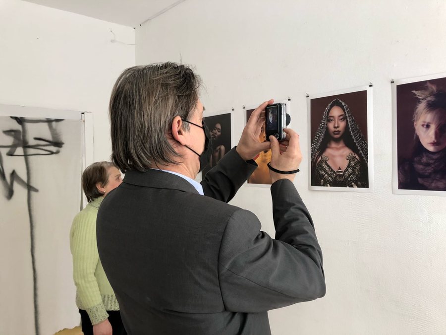 A visitor photographing Travis Zhang's portraits at his solo show at SPACE PLACE, Nizhny Tagil, February 2021